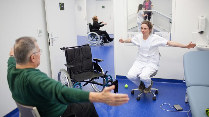 Photographie d'une séance de rééducation, une thérapeute évalue la motricité de son patient